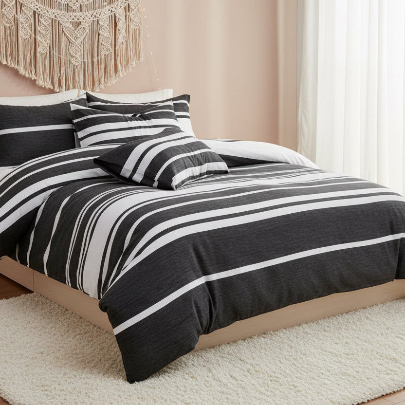 Black and white striped bedding set on a bed in a bedroom with decor elements.