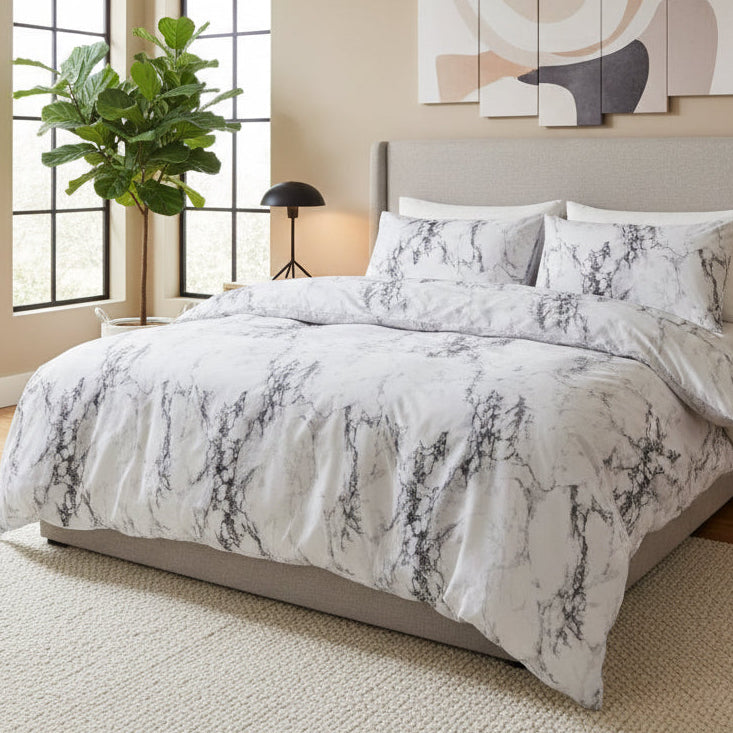 Marble patterned comforter set on a bed in a bedroom with curtains and lamps.