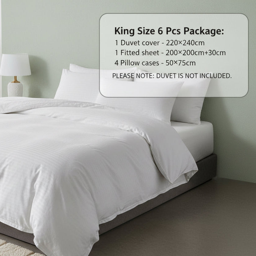 White bedding set on a bed in a bedroom with a plant and lamp in the background. Bedsheet hotel in Unite Arab emirates Dubai