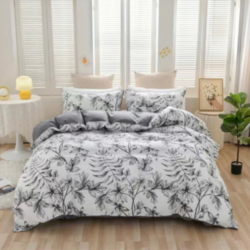 Floral patterned comforter set on a bed in a bright room with large windows.