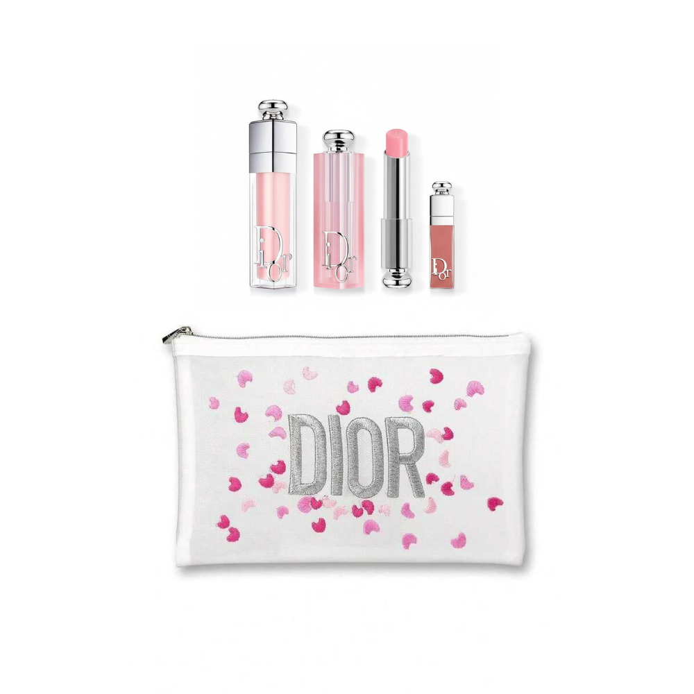 Dior makeup gift set featuring a white zippered pouch with silver glittery 'DIOR' lettering and pink heart confetti, alongside four matching cosmetic tubes in clear, pink, and nude shades.