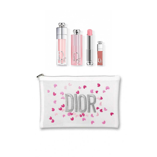 Dior makeup gift set featuring a white zippered pouch with silver glittery 'DIOR' lettering and pink heart confetti, alongside four matching cosmetic tubes in clear, pink, and nude shades.