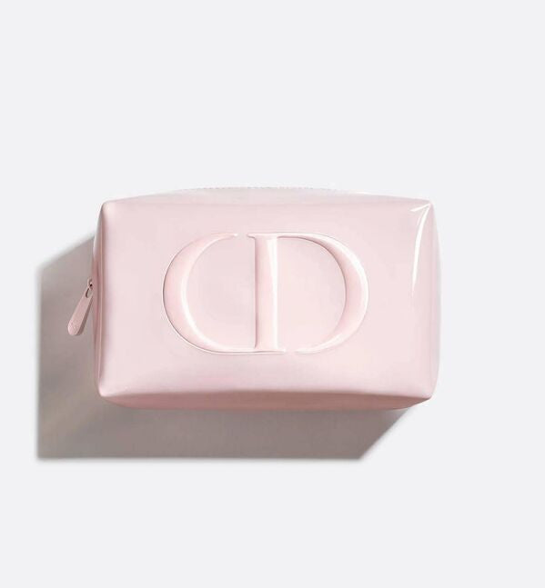 A light pink glossy cosmetic pouch with a large embossed 'CD' logo on the front, shown from a top-down angle on a light gray background with a soft shadow.