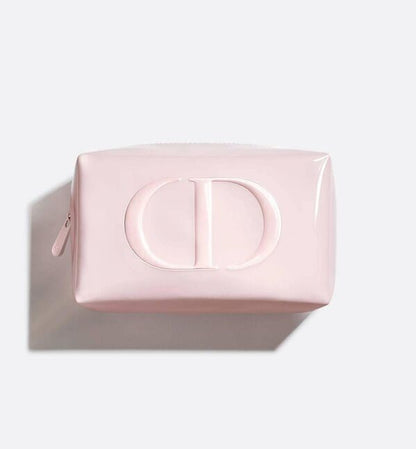 A light pink glossy cosmetic pouch with a large embossed 'CD' logo on the front, shown from a top-down angle on a light gray background with a soft shadow.