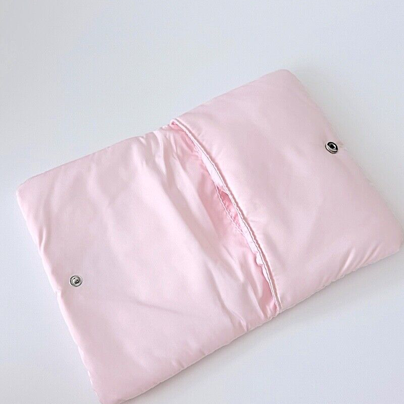 A folded light pink quilted blanket or comforter with two silver metal snap buttons, shown on a plain white background.