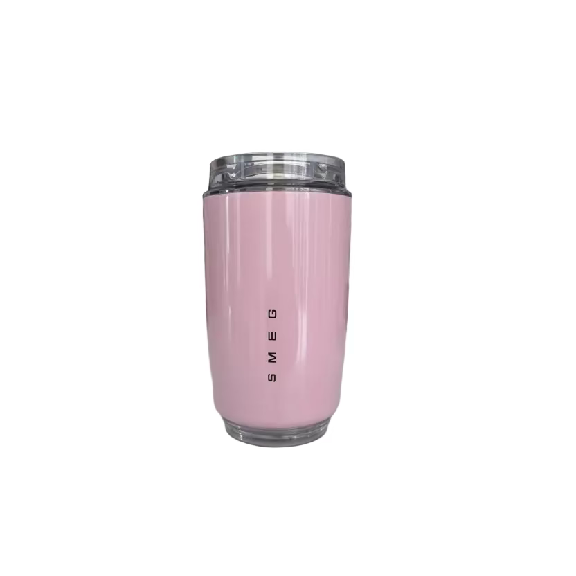 Pink travel mug with 'SMEG' branding on a kitchen counter