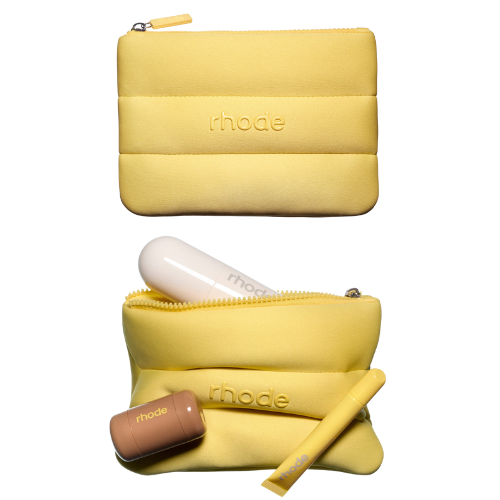Yellow pouch with 'rhode' branding containing a white device, brown container, and yellow tool on a white background.