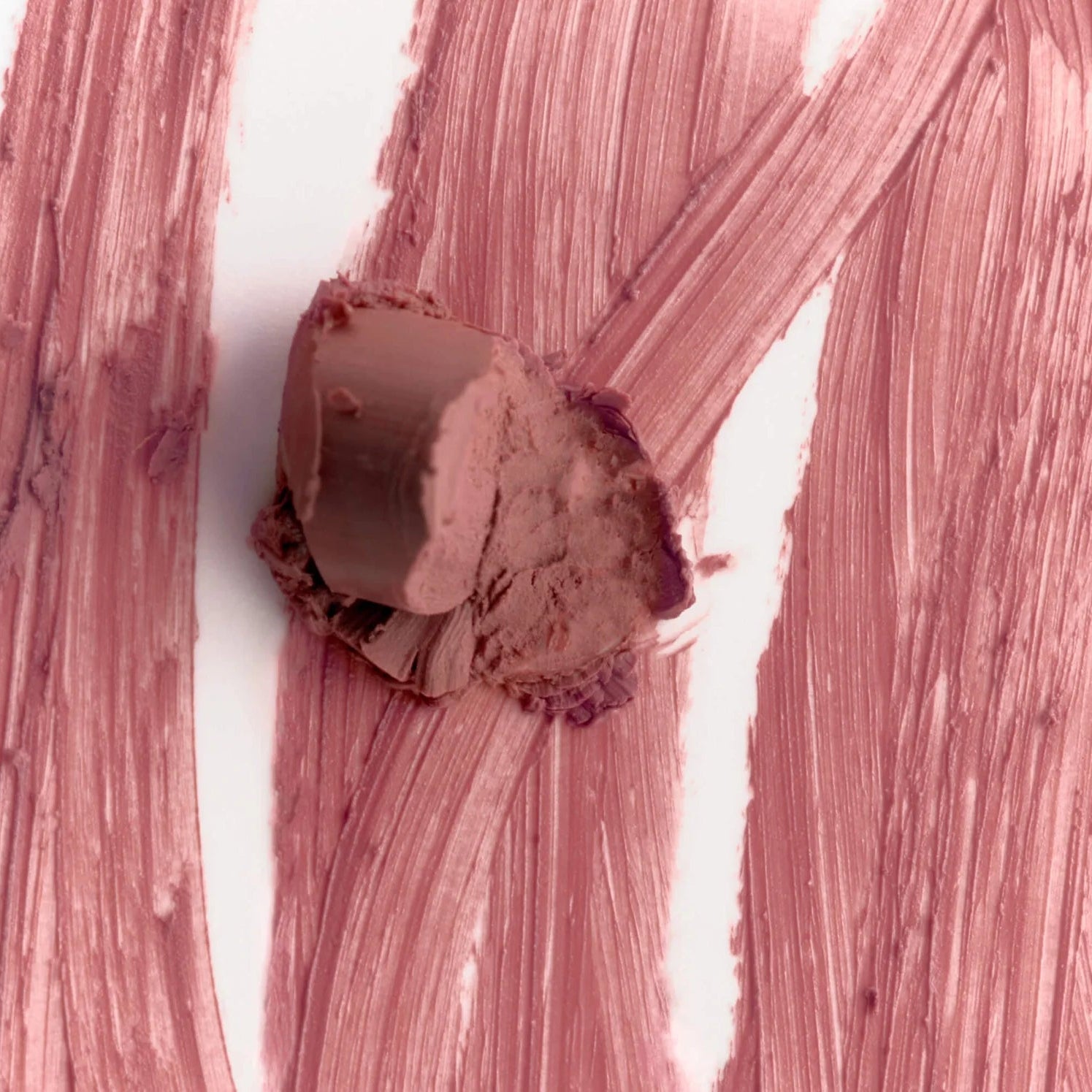 Close-up of a textured pink surface with a small round object on it