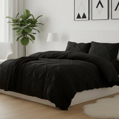 Modern bedroom with black bedding, white furniture, and decorative elements.