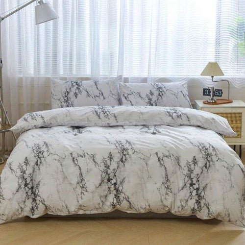 A king-size bedding set with a marble design displayed on a bed in a bedroom setting